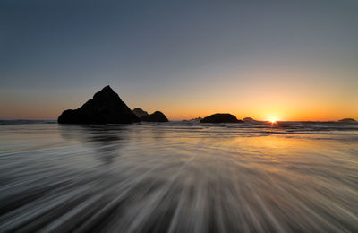 Scenic view of sea against clear sky during sunset