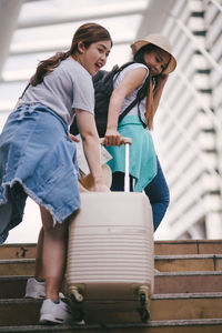 Tourist with luggage on steps in city