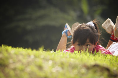 Girl lying on grassy field at park
