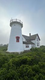 Lighthouse by sea against sky