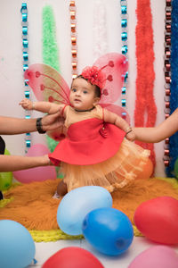 Cropped hands of parents holding cute baby girl wearing dress