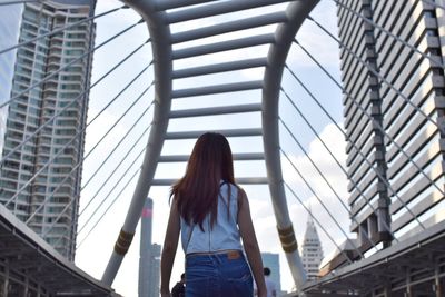 Rear view of woman walking  down chong nonsi bridge in bangkok thailand