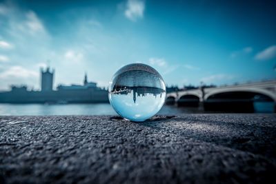 View of london through crystal ball against blue sky