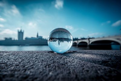 Close-up of crystal ball against blue sky