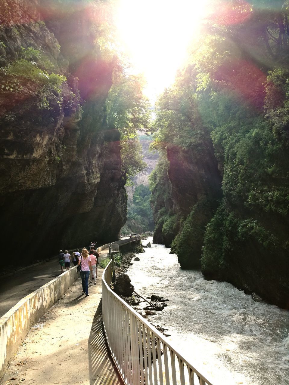 PEOPLE ON FOOTBRIDGE BY RIVER