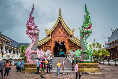 Group of people outside temple against building