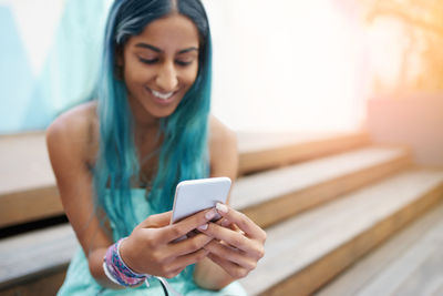 Smiling young woman using mobile phone