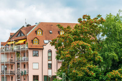 Low angle view of trees and building against sky