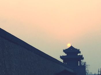 Low angle view of built structure against sky at sunset