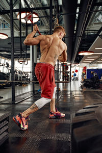 Rear view of man exercising in gym