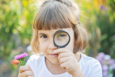 Girl looking through magnifying glass