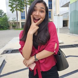 Portrait of smiling young woman standing outdoors