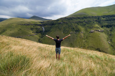 Man with open arms with a view of drakensberg