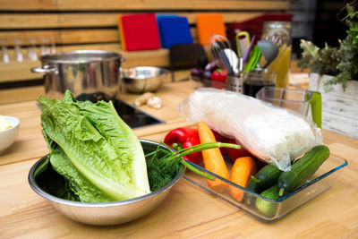 Set of raw foods on the table. bowl of lettuce, dill, cucumbers, peeled carrots, glass noodles