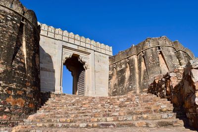 Low angle view of fort against clear blue sky