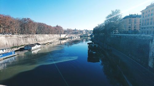 River amidst buildings in city against sky