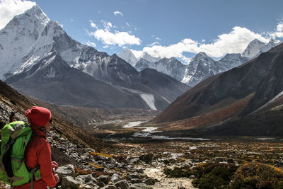 Hiker standing on mountain against sky