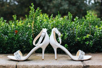 High heels on retaining wall against plants