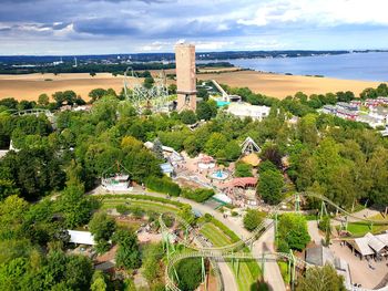 High angle view of trees and buildings against cloudy sky