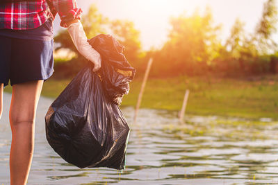 Woman holding leaf in lake
