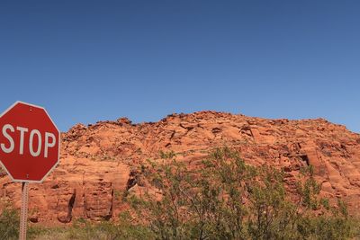 Text written on rock against clear blue sky