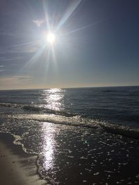 Scenic view of sea against bright sun