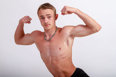 Portrait of shirtless young man against white background