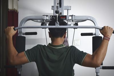 Rear view of man exercising in gym