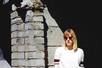 Portrait of woman standing against wall