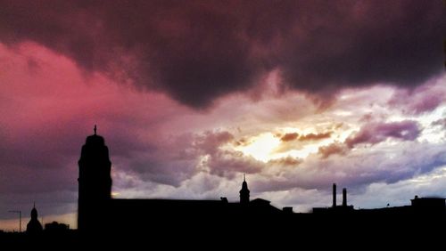 Silhouette city against sky during sunset