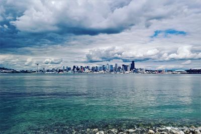 Panoramic view of sea and cityscape against sky