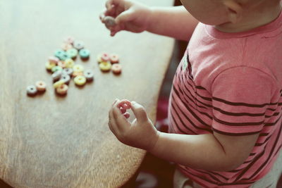 Midsection of boy having candies at home