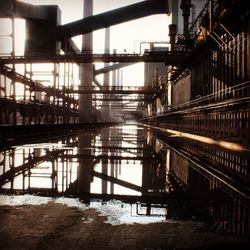 Reflection of abandoned factory in puddle