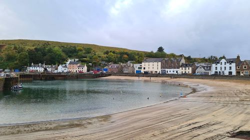 Scenic view of beach by buildings against sky