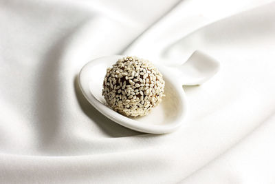 Close-up of food in spoon over white textile