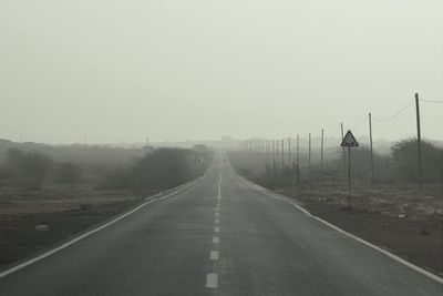 Road amidst fog against sky