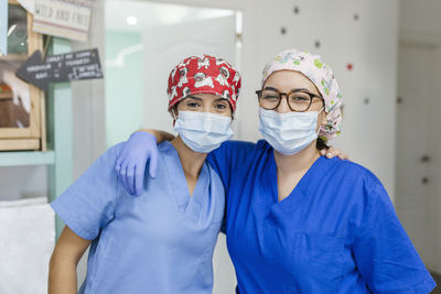 Healthcare worker standing with arm around at veterinary clinic