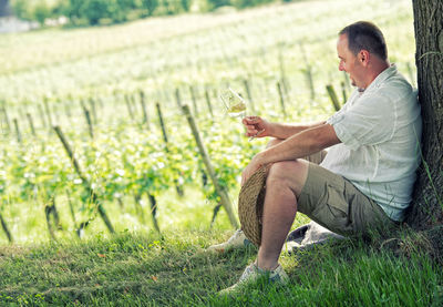 Side view of a man drinking glass