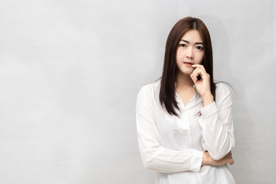 Portrait of beautiful young woman against white background