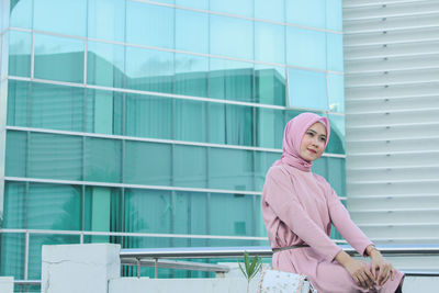 Side view of woman against building in city