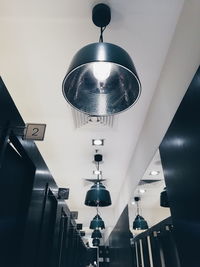 Low angle view of illuminated pendant lights hanging from ceiling