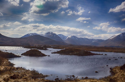 Scenic view of lake by mountains against sky