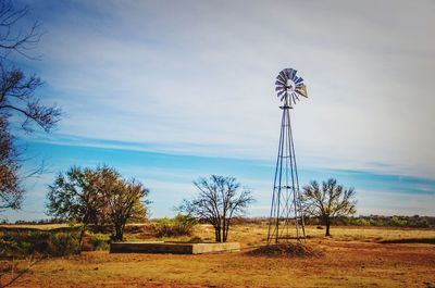 Low angle view of windmill on field against sky