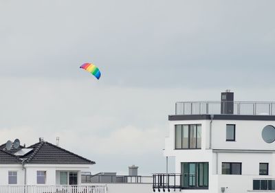 Low angle view of balloons in building against sky