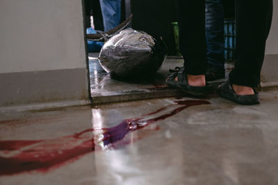 Low section of man standing on wet floor