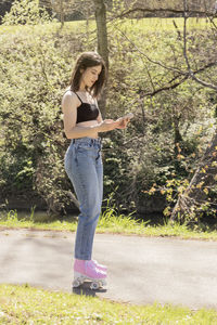 Brunette woman with roller skates looking at the mobile