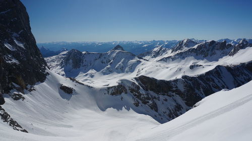 Scenic view of snowcapped mountains against clear sky