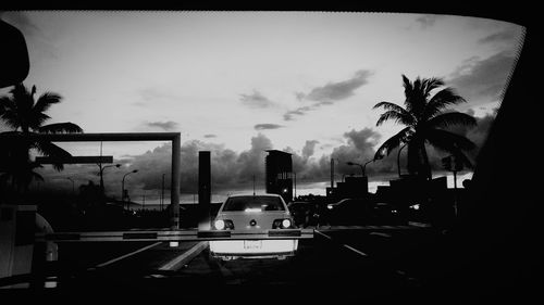 Cars on city street against sky