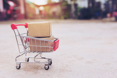 Close-up of cardboard boxes in miniature shopping cart