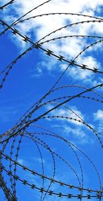 Low angle view of barbed wire against sky